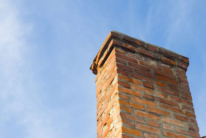 Closeup of Damaged Chimney with Blue Sky